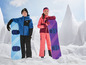 Dwójka dzieci w odzieży zimowej ze snowboardami na śniegu.