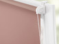 Różowa roleta z białym sznurkowym mechanizmem.
