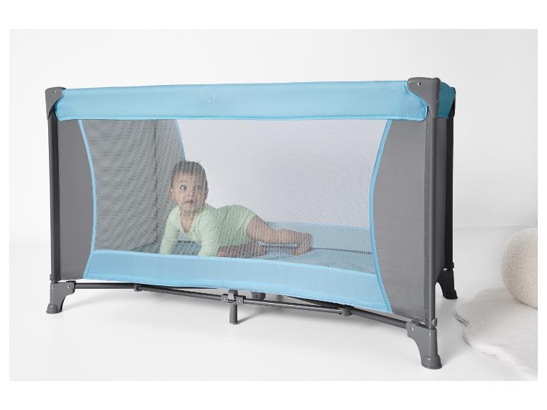 Dziecko leży w niebiesko-szarej podróżnej łóżeczku.