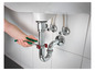 Hydraulik używa klucza do zamocowania rury odpływowej od zlewu.