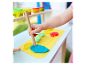 Dziecko bawi się plasteliną Play-Doh i narzędziami do modelowania przy drewnianym stole.