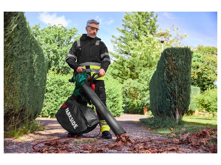 Mężczyzna używa dmuchawy do liści Parkside, zbierając liście na podjeździe.