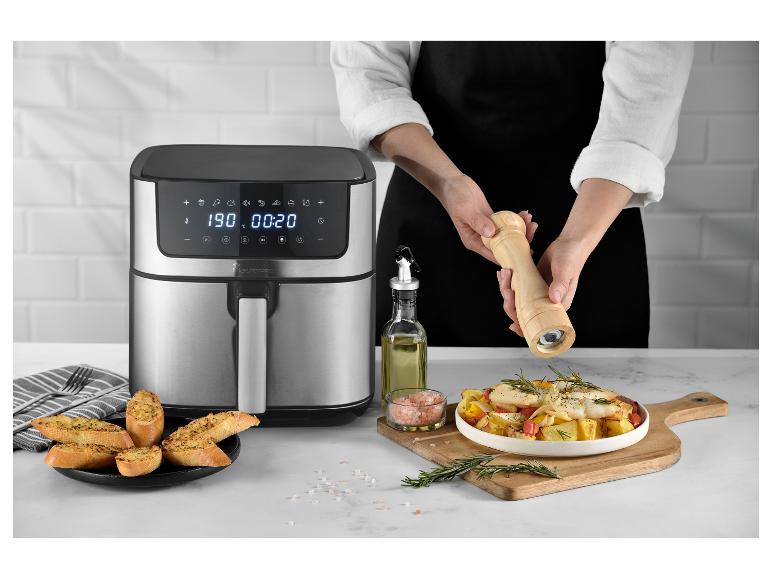 Frytkownica beztłuszczowa MasterPRO z gotowym jedzeniem i osobą przyprawiającą.