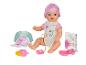 Lalka Baby Born z akcesoriami, takimi jak butelka, smoczek i książka.