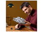 Mężczyzna trzyma w rękach LEGO Star Wars Millennium Falcon.