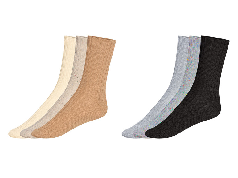 Trzy pary skarpetek w kolorze beżowym, szarym i czarnym z kolorowymi kropkami.