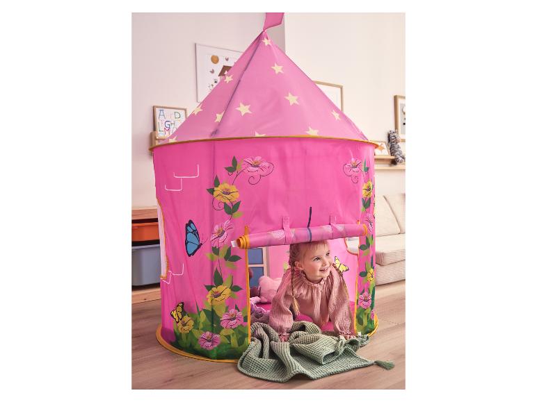 Dziewczynka bawi się w różowym namiocie do zabawy z motywami kwiatów i motyli