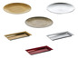 Okrągłe talerze w kolorze złotym i srebrnym oraz prostokątne tace.