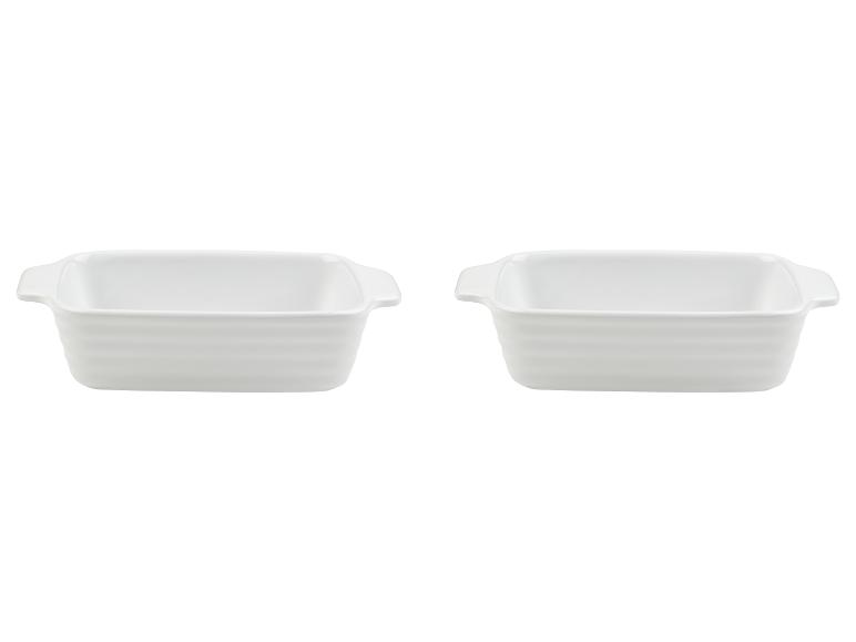 Dwie białe formy do zapiekania z uchwytami.