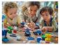 Dorosły i dwoje dzieci bawią się kolorowymi klockami LEGO Duplo na podłodze.