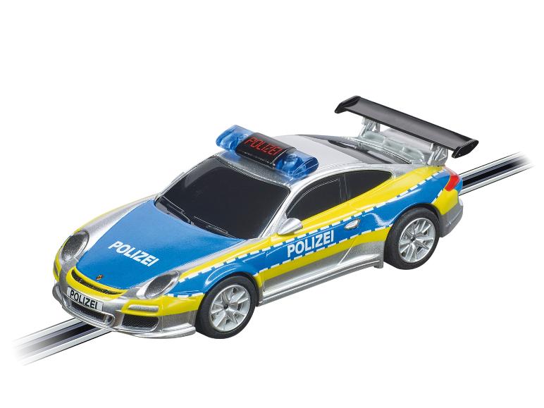 Srebrny samochód policyjny Porsche na torze wyścigowym.