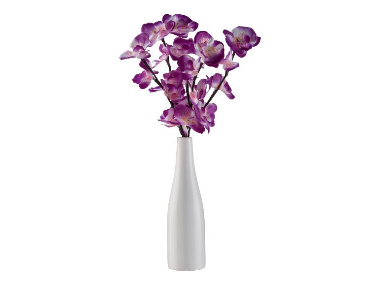 Sztuczne fioletowe orchidee w białym wazonie