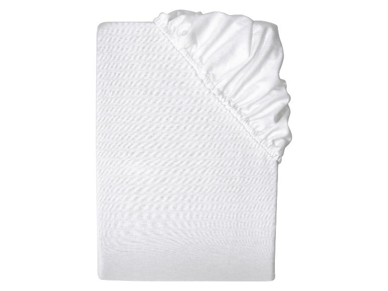 Białe prześcieradło z gumką złożone na białym tle