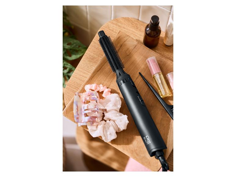 Szczotka do stylizacji Cien Beauty, akcesoria do włosów i produkty do pielęgnacji włosów na drewnianej tacy.