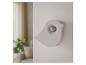 Biały czujnik ruchu w kształcie ptaka zamontowany na ścianie w salonie.