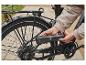 Osoba pompująca oponę rowerową przenośną pompką Crivit.