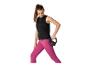 Kobieta w czarnym topie i różowych legginsach ćwicząca z kettlebell.