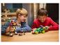 Dwóch chłopców bawi się zestawami LEGO, robotem i samochodem wyścigowym, przy drewnianym stole.