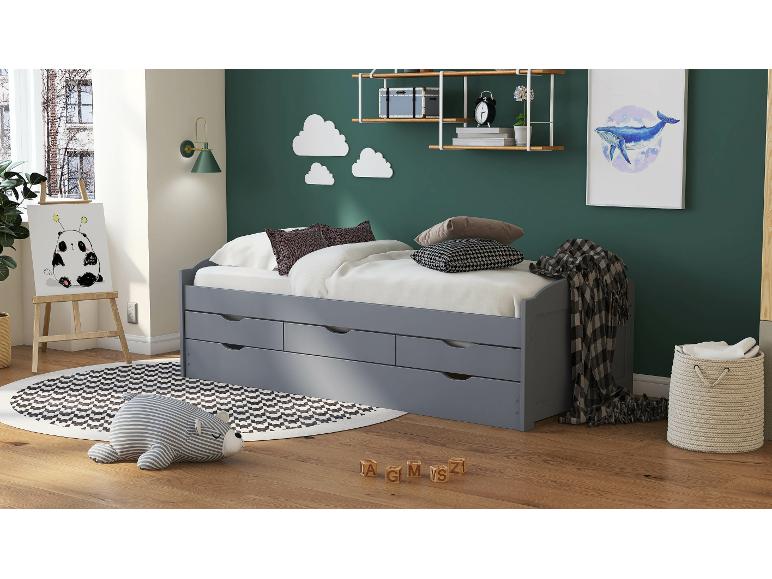 Szare łóżko z trzema szufladami i czarno-białym dywanem w pokoju dziecięcym.