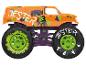 Pomarańczowy monster truck w stylu błazna, z zielonymi i czarnymi kołami.