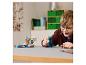 Chłopiec bawi się zestawem LEGO Minecraft z figurką Wardena i małą budowlą.