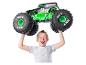 Chłopiec trzyma zabawkę monster truck Grave Digger Monster Jam nad głową.