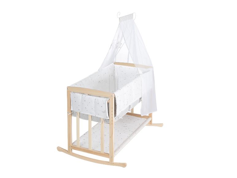 Drewniane łóżeczko dziecięce z baldachimem i pościelą w gwiazdki i księżyce