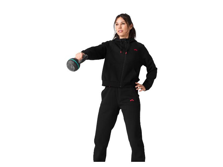 Kobieta w czarnym dresowym komplecie z kettlebell.