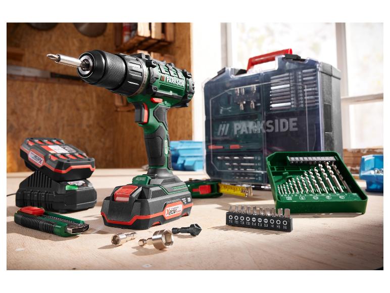 Wiertarka Parkside, akumulatory, ładowarka i akcesoria na drewnianym stole.