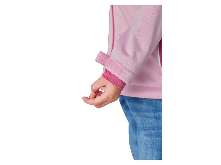 Rękaw różowej kurtki softshell z zapięciem na rzep i elastycznym mankietem, noszony z dżinsami.