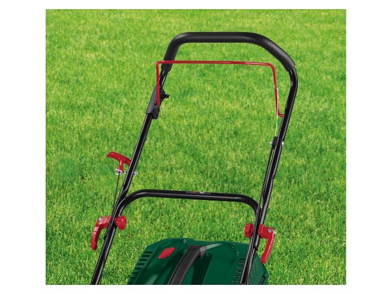 Uchwyt kosiarki z czerwonymi dźwigniami na zielonym trawniku