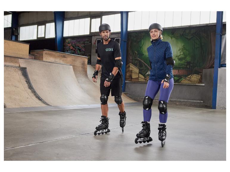 Rolki, ochraniacze i kaski na rampie skate'owej.