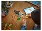 Dziecko buduje papugę LEGO Creator 3-w-1, postępując zgodnie z instrukcjami na tablecie.