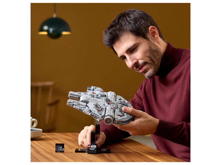 Mężczyzna trzyma w rękach LEGO Star Wars Millennium Falcon.