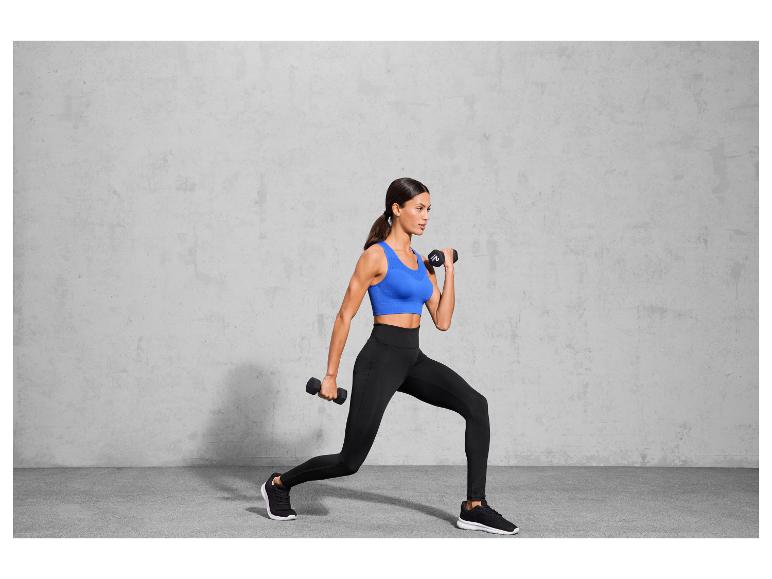 Kobieta w sportowym stroju ćwiczy z hantlami.