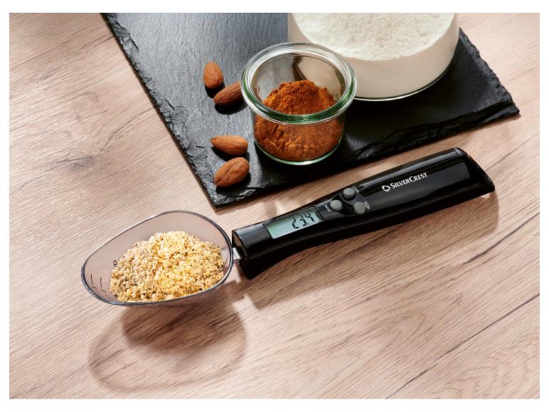 Cyfrowa łyżka pomiarowa SilverCrest z migdałami, mąką i przyprawami na łupkowej desce.