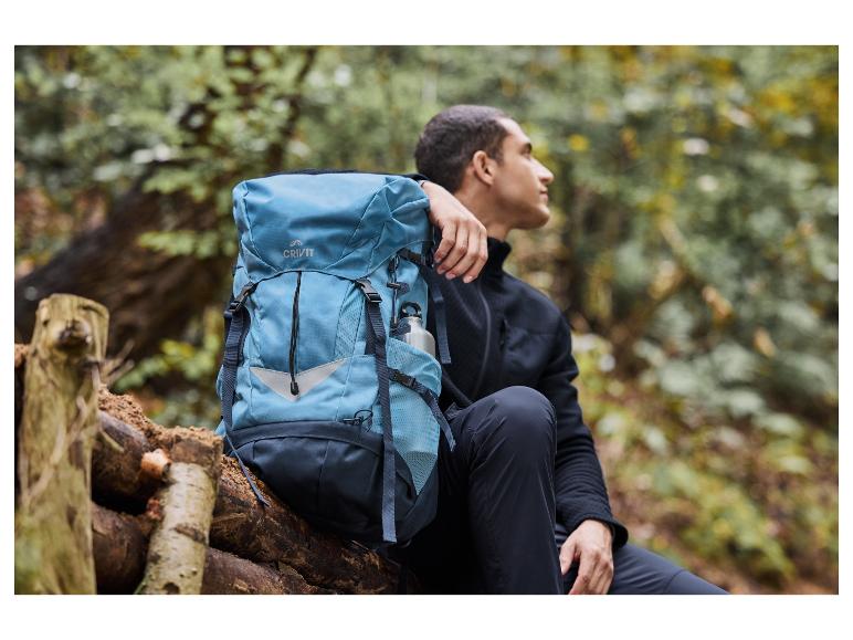 Mężczyzna z niebieskim plecakiem Crivit w lesie