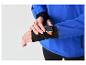 Mężczyzna w niebieskiej kurtce i czarnych legginsach, regulujący smartwatch z pomarańczowym paskiem.