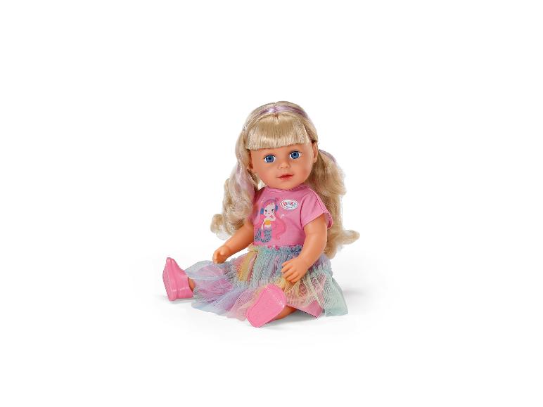 Lalka BABY born z blond włosami, różową koszulką z syrenką i tęczową tiulową spódniczką.