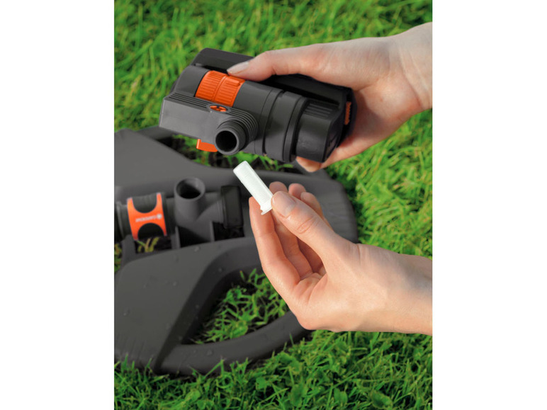 Ręka trzymająca zraszacz Gardena i filtr.