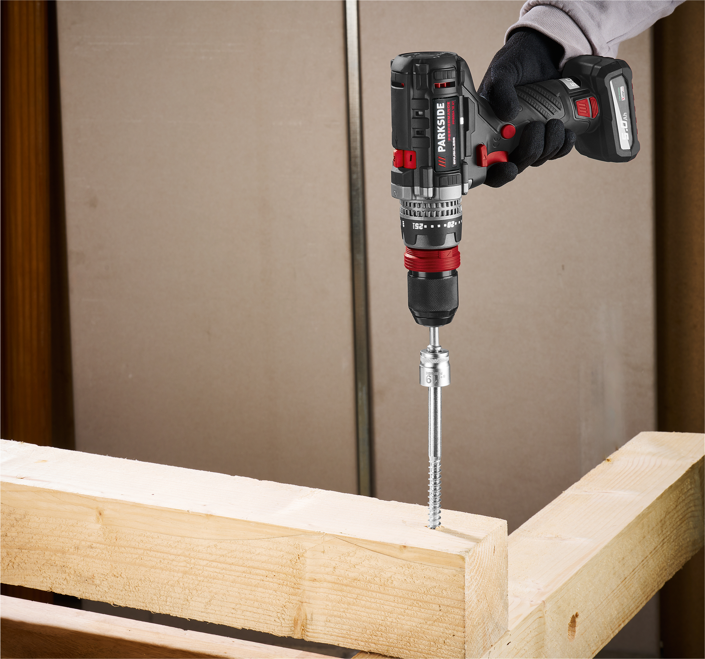 Akumulatorowa wkrętarka Parkside Performance wkręca wkręt w drewnianą belkę.