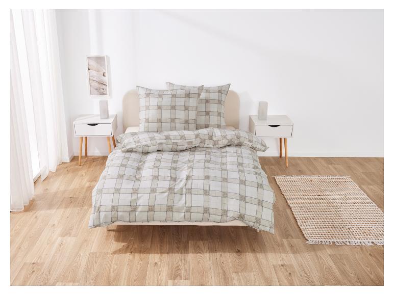 Pościel w kremowo-beżową kratę na łóżku.