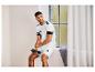 Mężczyzna w białej koszulce i szortach Adidas trzyma czarną butelkę na wodę.