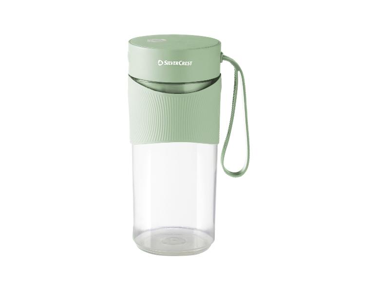 Zielony przenośny blender SilverCrest z przezroczystym pojemnikiem i uchwytem.