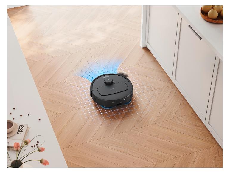Czarny robot odkurzający czyści drewnianą podłogę, z widoczną symulacją sprzątania.