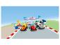 Trzy samochody wyścigowe LEGO Duplo Formuły 1 na linii startu z trofeum i stacją mechanika.