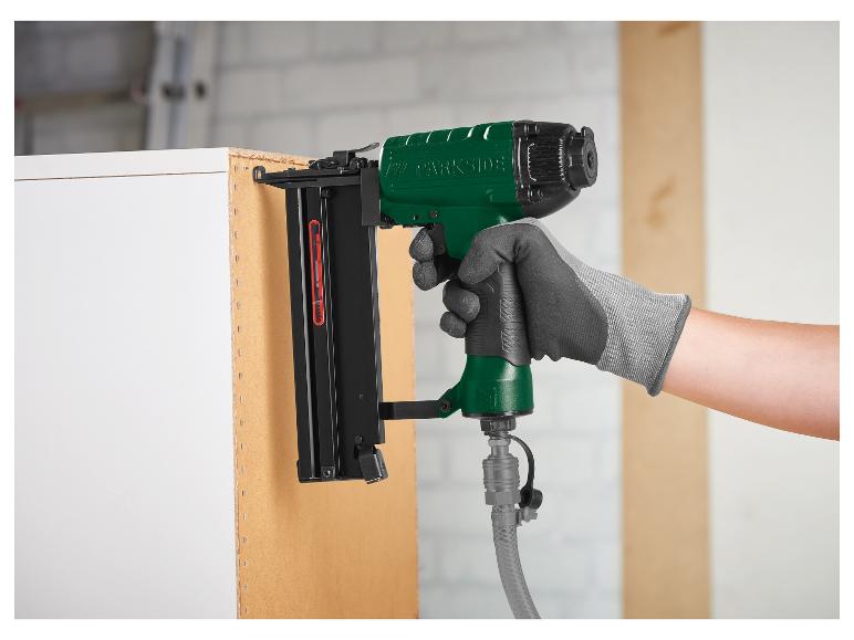 Osoba używa zielonej tacker Parkside do mocowania drewna.