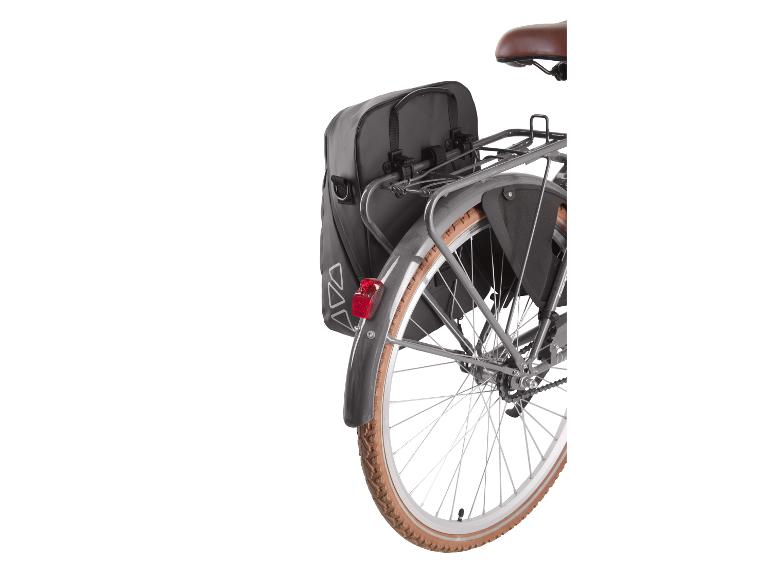 Czarne tylne sakwy rowerowe na bagażniku rowerowym z brązową oponą.