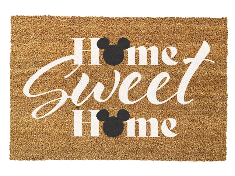 Brązowa wycieraczka z napisem „Home Sweet Home” i czarnymi głowami myszy.