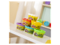 Kilka małych pojemników z plasteliną Play-Doh ułożonych na stole.